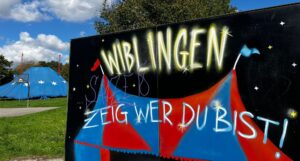 Graffiti Schild "Wiblingen, zeig wer du bist" und Zelt